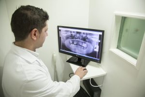 Dentist looking at X-Ray on screen